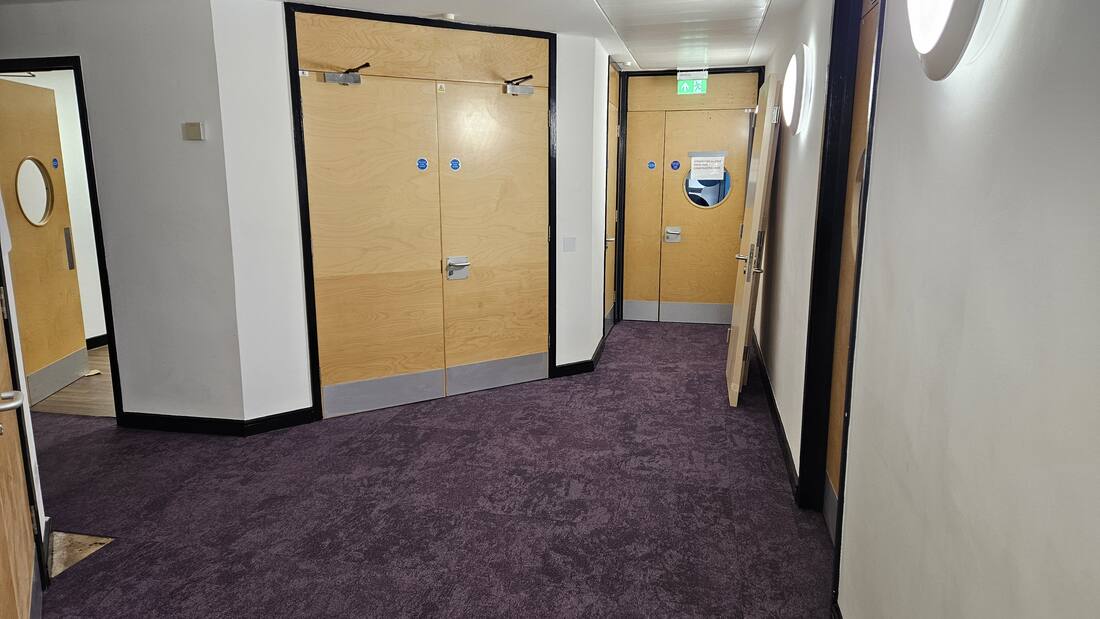 Commercial office corridor cleaning near fire door bay