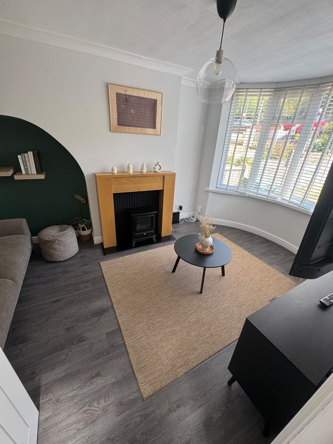 Living room with fireplace and bay window, cleaned between guest stays