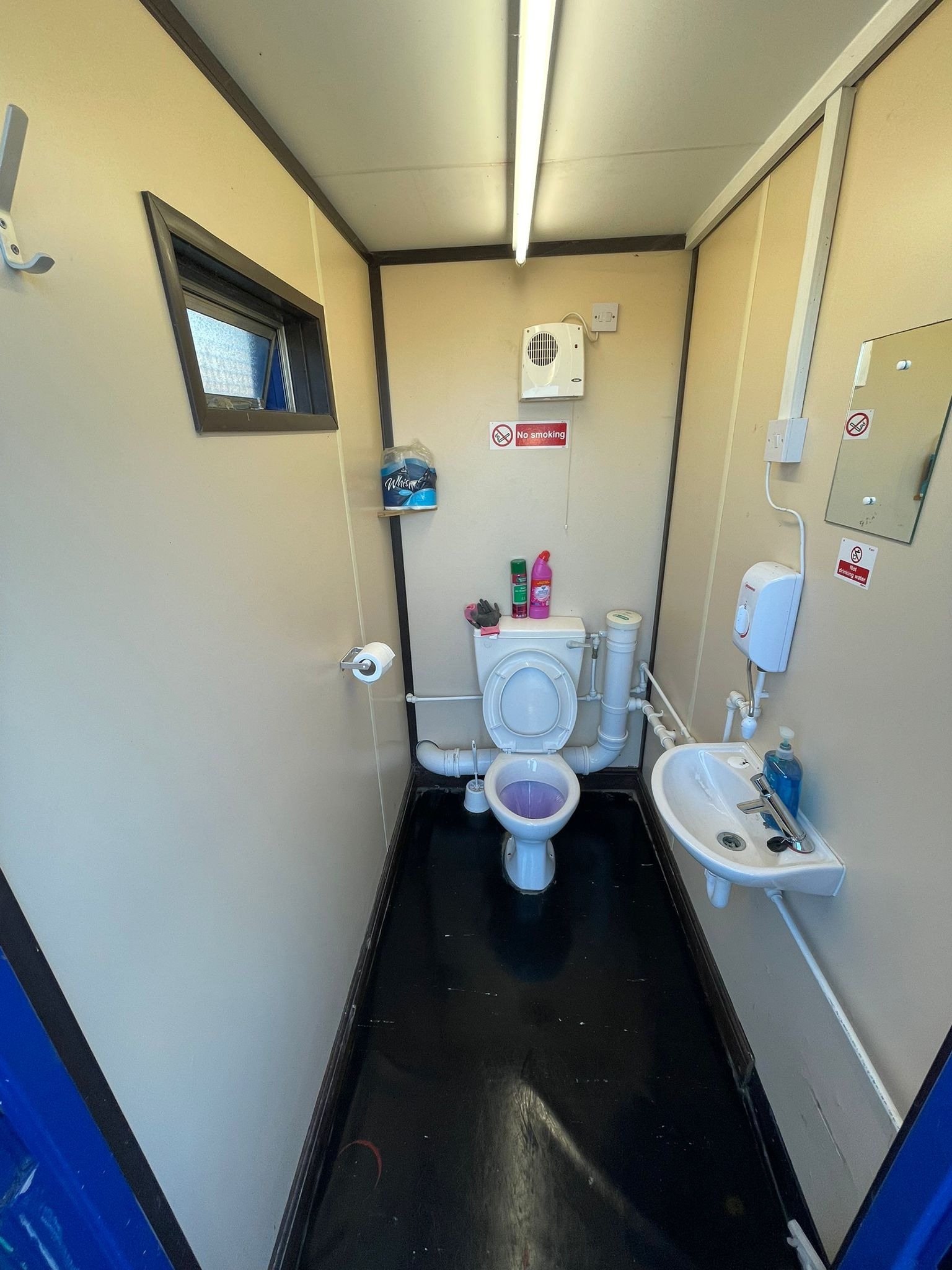 Site welfare unit toilet cubicle cleaned on a construction site contract